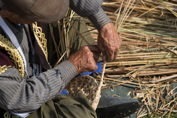 the man has veteran hands make basket with wicker.
