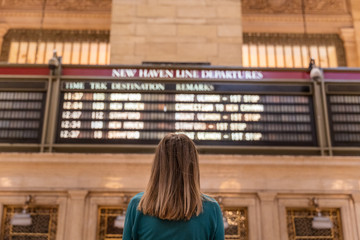 woman checking the train timetable in the grand central terminal in new york