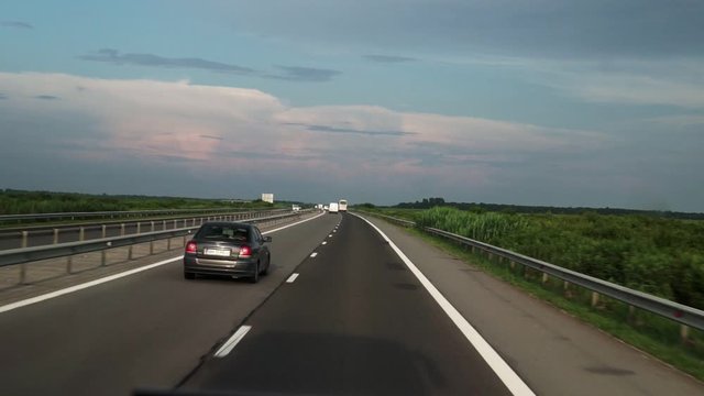 FPV: Driving along the highway. View of the road from the car window. Cars go to a meeting.