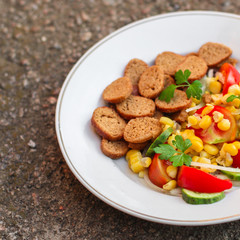 salad vegetables and croutons (tomato, cucumber, onion, cracker, corn and other ingredients) menu. top food background. copy space