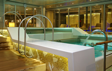 Indoor swimmingpool with hot tub whirlpool inside thermal suite in spa or wellness area onboard luxury modern cruiseship or cruise ship liner for beauty and balance