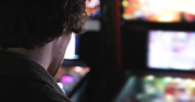 Arcade: Rear View Of Man Playing Pinball