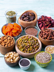 nuts, seeds and dried fruis on wooden surface