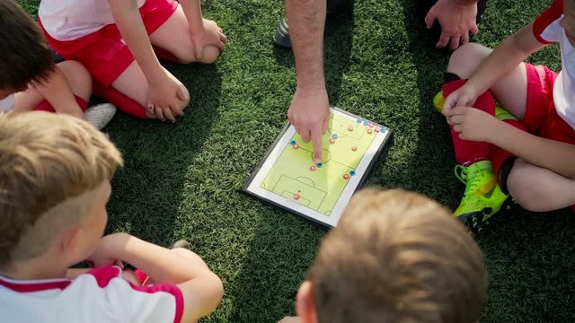 coach explains game tactic moving coloured figures