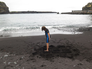 girl with neoprene playing in the beach