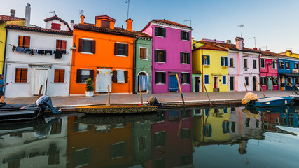 Fototapeta na wymiar Colorful houses are reflected in the dark waters of the canal