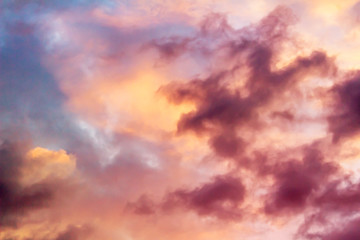 Naklejka na ściany i meble Fluffy pink clouds against a blue sky at sunset