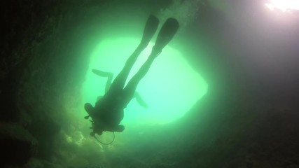 Large cave underwater with divers