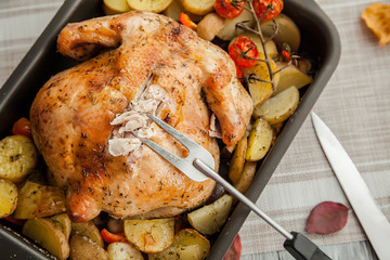 roast chicken and potato slices for thanksgiving day holiday, close up.