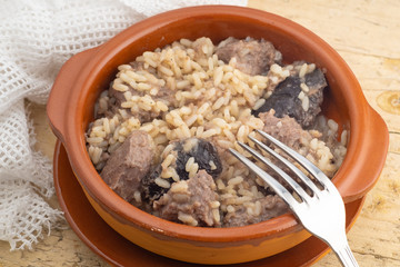 Rice dish with pork cheeks and mushrooms, typical recipe of Spanish and Mediterranean cuisine