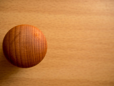 Wooden brown knob on a wooden background