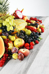Tropical fruits background, many colorful ripe fruits with strawberries, grapes and cherries on...