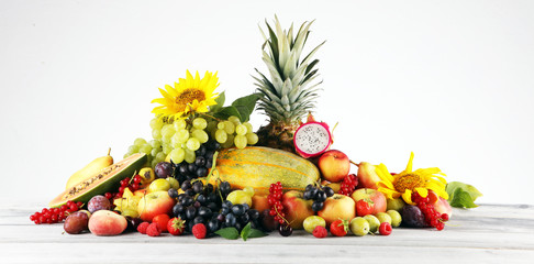 Tropical fruits background, many colorful ripe fruits with strawberries, grapes and cherries on...