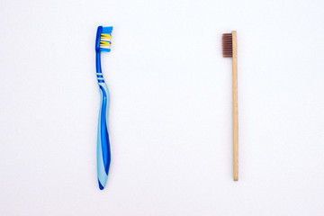Bamboo and plastic toothbrush on the background, top view. Zero waste concept, choice alternative, save the planet.