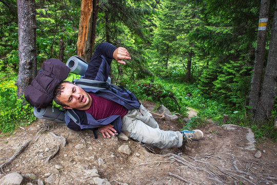 Theme Insurance Company. Man having trouble feeling knee pain during travel in forest. Health problem in journey.