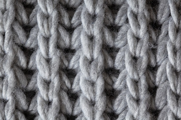 Knitted woolen textured surface, macro. Soft grey merino wool pattern backdrop, closeup. Autumn and winter flat lay. Scandinavian minimal style