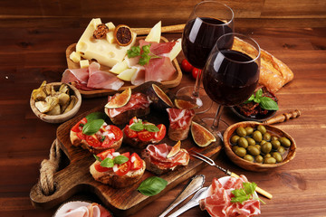Italian antipasti wine snacks set. Cheese variety, Mediterranean olives, Prosciutto di Parma, tomatoes, artichokes