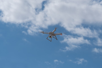 Fototapeta na wymiar Drone, copter is flying in the blue sky. Modern video and aerial photography