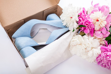 Female blue wedding shoes in box with flowers on white background