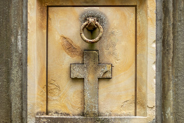 Old crypt, tomb in the cemetery. The door is decorated with a cross.