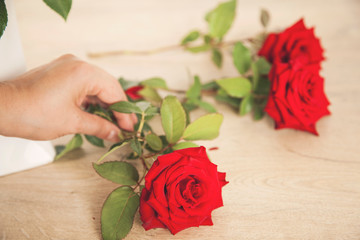woman hand red roses on desk