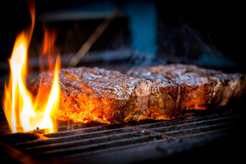 Barbecue ancho steak. Grilled ancho steak on barbecue grill with fire. BBQ Steak ancho meat steak.