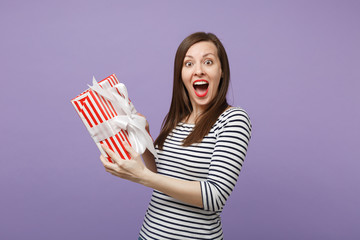 Young brunette woman girl in casual striped clothes posing isolated on violet purple background...