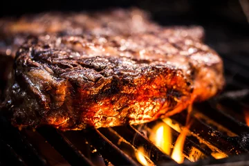 Foto op Canvas Gegrilde ancho steak op barbecue grill met vuur. BBQ Steak ancho vlees steak © carolaraujo