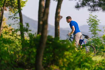 Adventurous mountain biker riding his bike fast through the woods ( forest ) while enjoying the green nature.