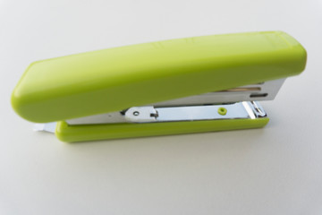 Green stapler isolated on white background.
