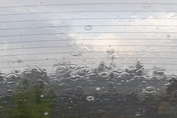 Rain drops on car glass in rainy day, summer is over and autumn fall storms and bad weather comes