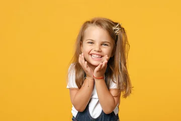 Foto op Canvas Little cute child kid baby girl 4-5 years old wearing light denim clothes isolated on pastel yellow wall background, children studio portrait. Mother's Day, love family, parenthood childhood concept. © ViDi Studio