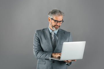 studio shot of business man holding laptop computer