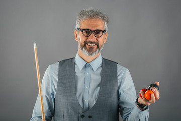 studio shot of billiard player holding stick and balls