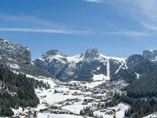 Fototapeta na wymiar Selva Val Gardena during a sunny winter Day surrounded by the Dolomites in South Tyrol