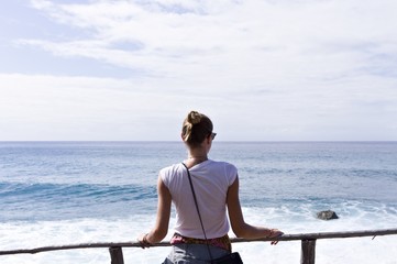 Fototapeta na wymiar A blonde girl is looking the Atlantic Ocean (Madeira, Portugal)