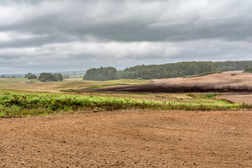 Fototapeta na wymiar plowed field after harvesting, agricultural landscape overcast autumn day