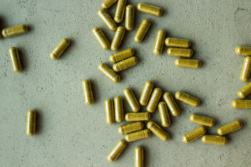 biologically active food supplement vitamin capsule pills scattered on a gray concrete background