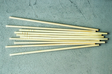 wooden chopsticks sushi rolls on a gray concrete background