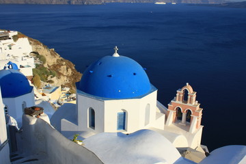 Blue church domes and white buildings in Oia