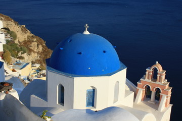 Obraz premium Blue church domes and white buildings in Oia