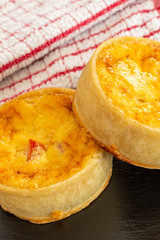 Two Small Fresh bakes Quiches on a Small Black Slate Tray.