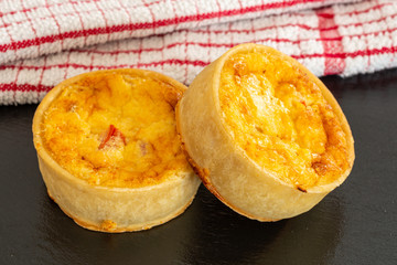 Two Small Fresh bakes Quiches on a Small Black Slate Tray.
