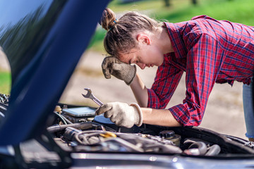 Unhappy upset stressed woman driver having trouble with broken car during a trip. Need for service and repair car for failed engine