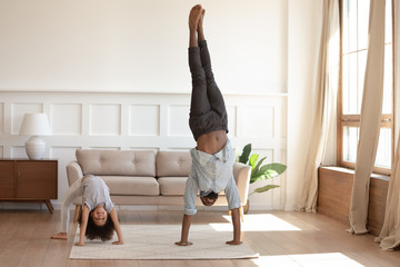 Smiling black family doing morning exercises together at home.