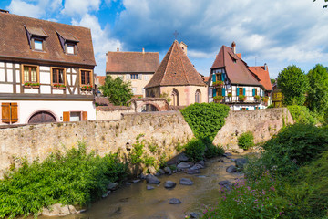 Fototapeta na wymiar Colorful houses along the river. Medieval village Kaysersberg. Alsace. France.