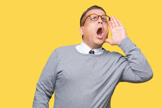 Middle age bussines arab man wearing glasses over isolated background shouting and screaming loud to side with hand on mouth. Communication concept.