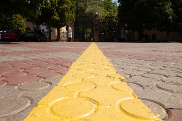 Yellow line marking on the paving stones. Solid line. Selective focus.