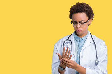 Young african american doctor woman wearing medical coat over isolated background Suffering pain on...