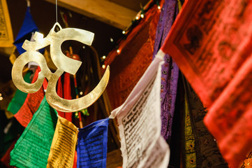 Nepalese prayer flags and a hanging brass symbol representing Lord Vishnu
